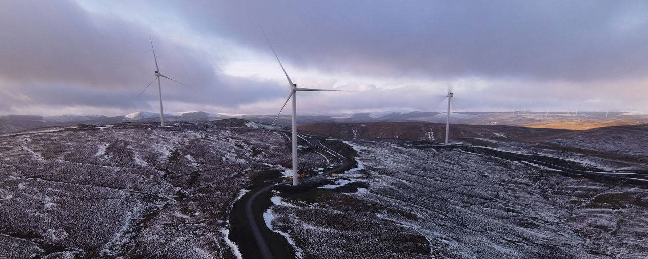 Three wind turbines in a hilly Scottish landscape