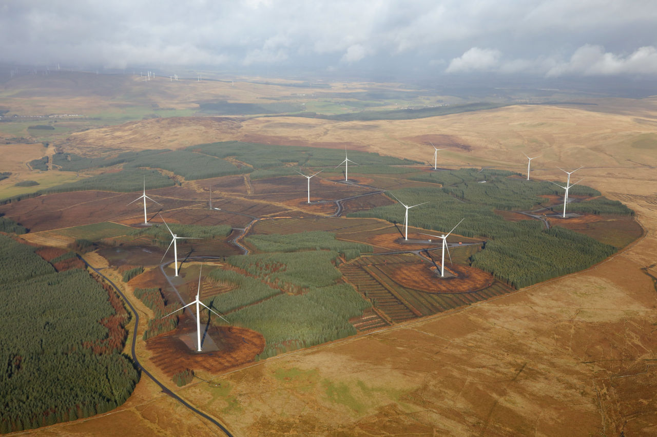 Three wind turbines in a hilly Scottish landscape