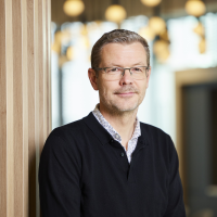 man wearing glasses looking into the camera and smiling